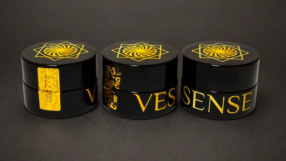 Tre vasetti VESSENSE LE BAUME GRAND LARGE in vetro scuro con lettere d'oro e sigilli olografici numerati